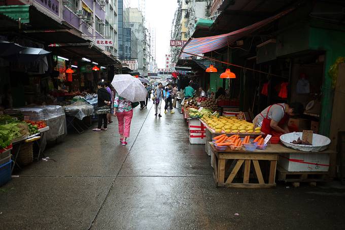 lady walking in rain in Hong Kong market