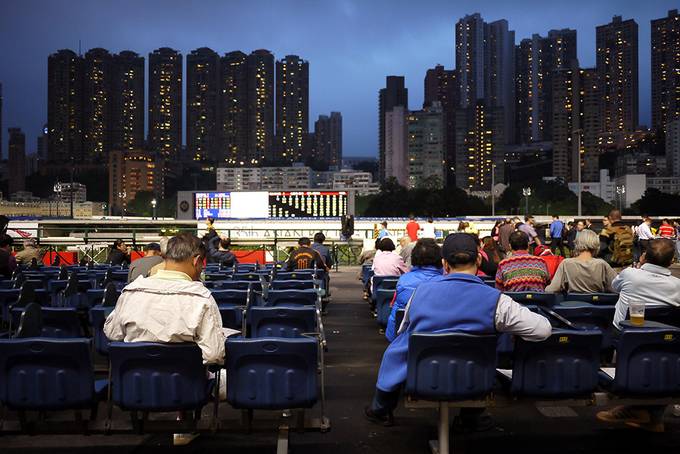 men waiting for the horse race to start in Hong Kon
